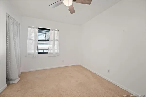 a view of empty room with ceiling fan
