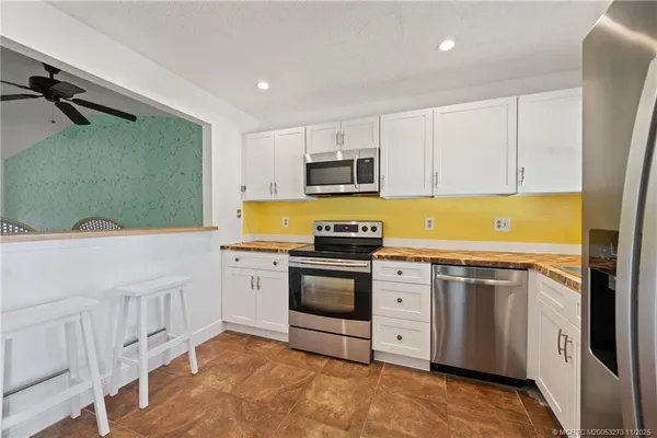 a kitchen with stainless steel appliances granite countertop a stove a sink and a refrigerator