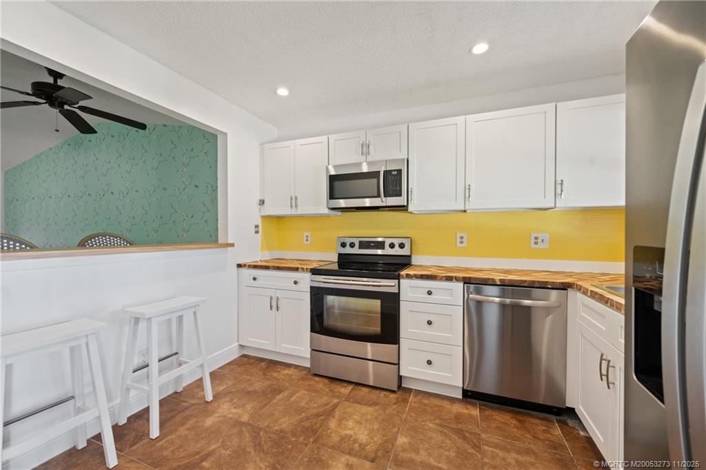 1210 Southeast Parkview Place, Unit 9 Stuart, FL 34994 - Photo 6 of 36 a kitchen with stainless steel appliances granite countertop a stove a sink and a refrigerator