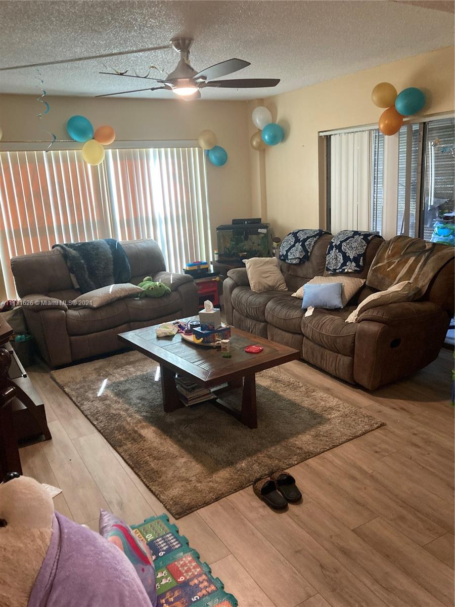4172 Inverrary Drive, Unit 112 Lauderhill, FL 33319 - Photo 17 of 18 a living room with furniture a rug and a chandelier