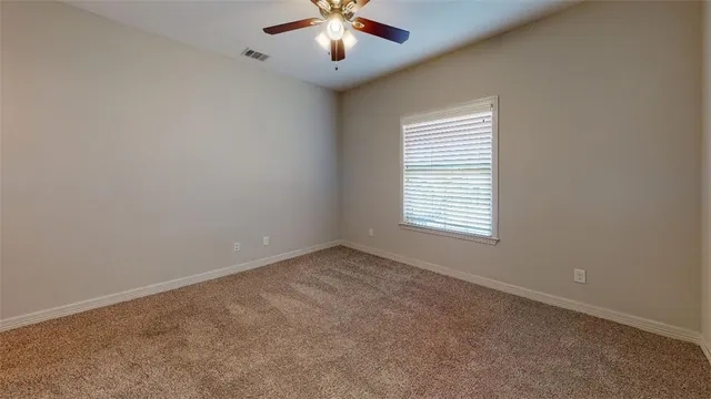 an empty room with closet and a chandelier fan