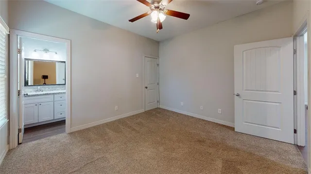 a bathroom with a granite countertop toilet a sink and wooden floor