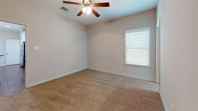 a view of an empty room with window and cabinet