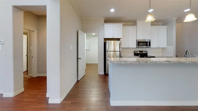 a view of a kitchen with furniture and wooden floor