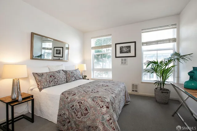a bedroom with a bed and a potted plant