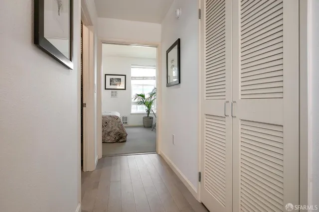 a view of a hallway with wooden floor and furniture