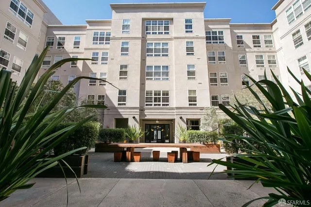 a view of a building with a garden and sitting area