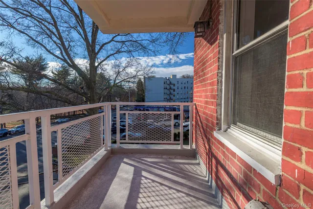 a view of a balcony with two couches and deck with wooden floor and fence