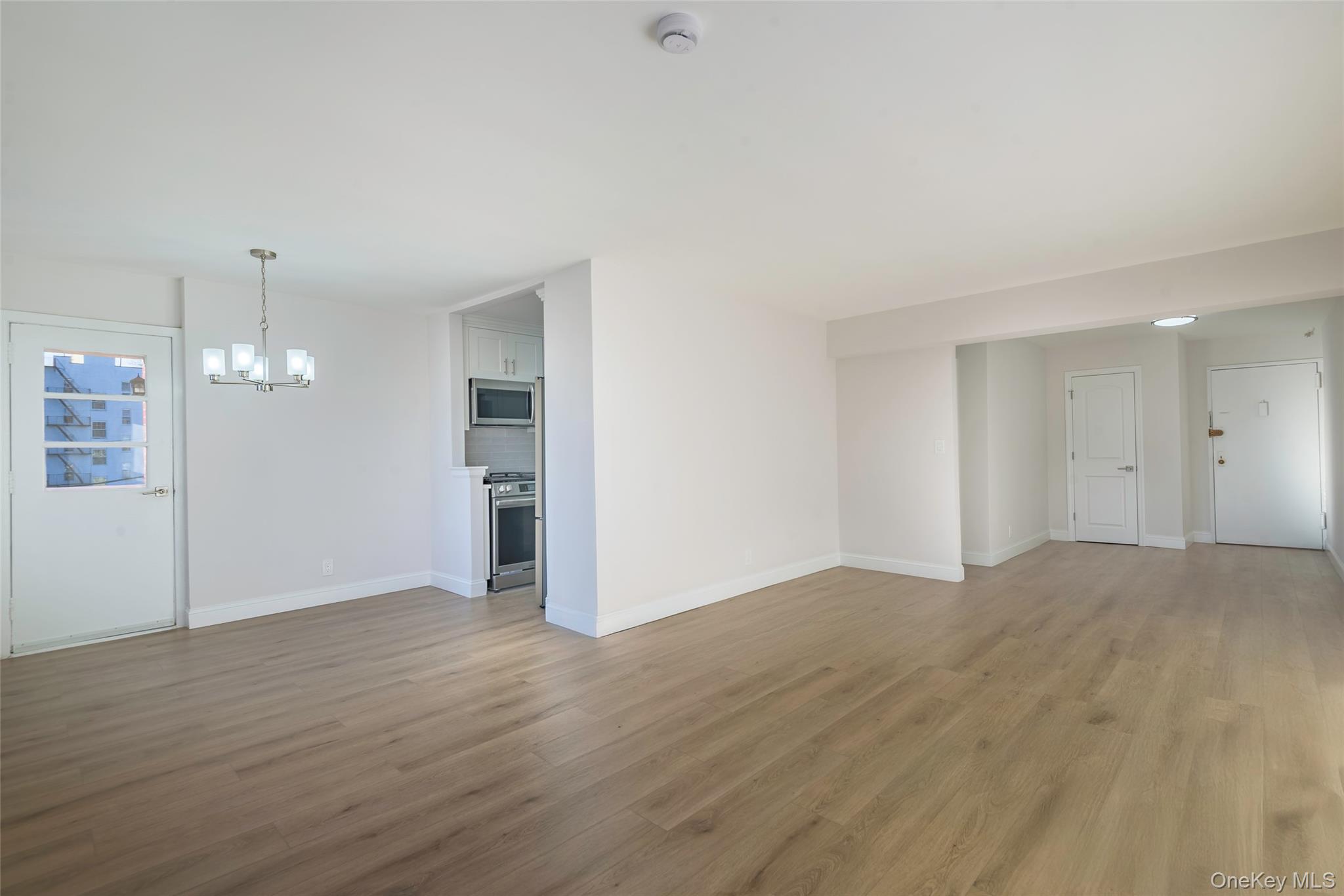 125 Bronx River Road, Unit 2E Yonkers, NY 10704 - Photo 5 of 31 a view of an empty room with wooden floor and kitchen