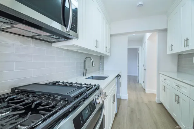 a kitchen with stainless steel appliances granite countertop a stove and a wooden cabinets