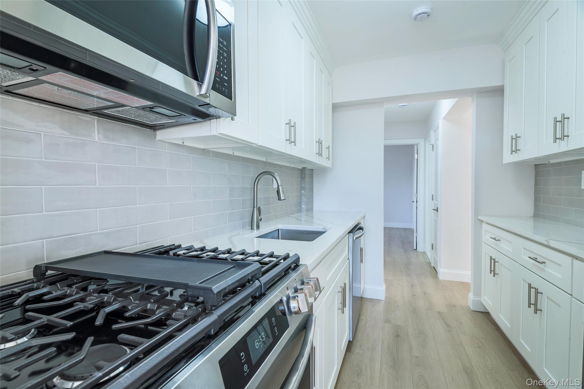 125 Bronx River Road, Unit 2E Yonkers, NY 10704 - Photo 10 of 31 a kitchen with stainless steel appliances granite countertop a stove and a wooden cabinets