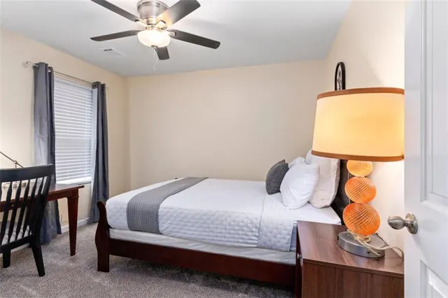 a bedroom with a bed lamp and a window