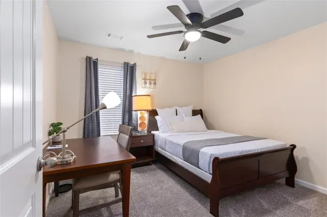 a bedroom with a bed a table and a potted plant