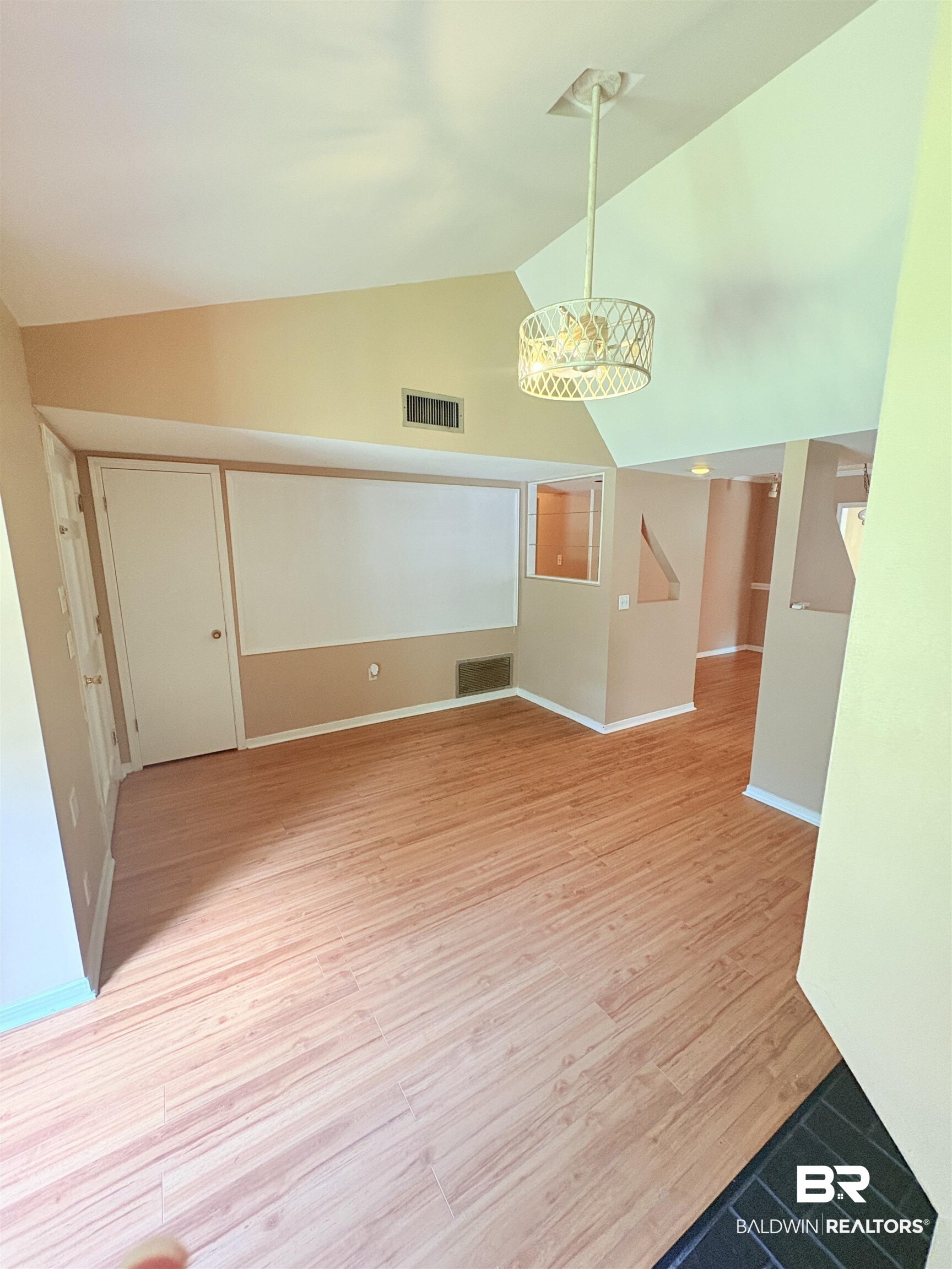 8070 Middle Ring Road Mobile, AL 36619 - Photo 15 of 26 Spare room with light wood-type flooring, high vaulted ceiling, and a chandelier
