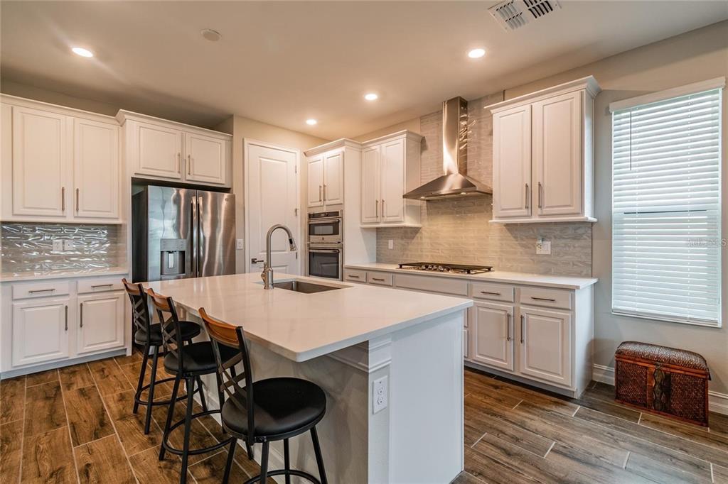 4738 Tramanto Lane Wesley Chapel, FL 33543 - Photo 15 of 45 a kitchen with stainless steel appliances granite countertop a stove refrigerator sink and cabinets