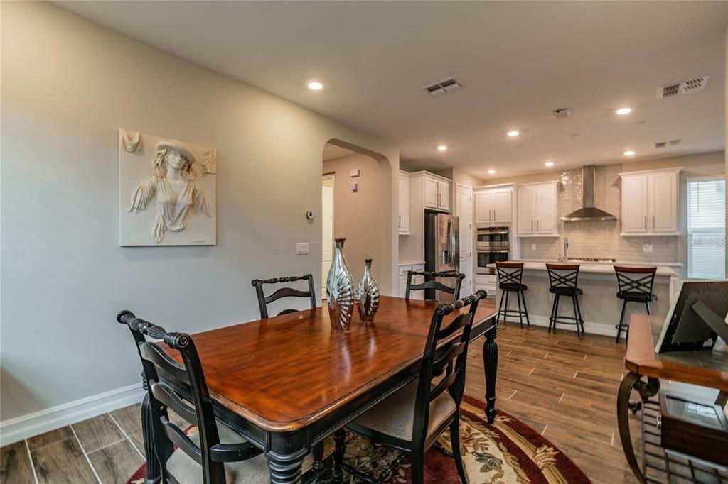 4738 Tramanto Lane Wesley Chapel, FL 33543 - Photo 21 of 45 a dining room with stainless steel appliances a table and chairs