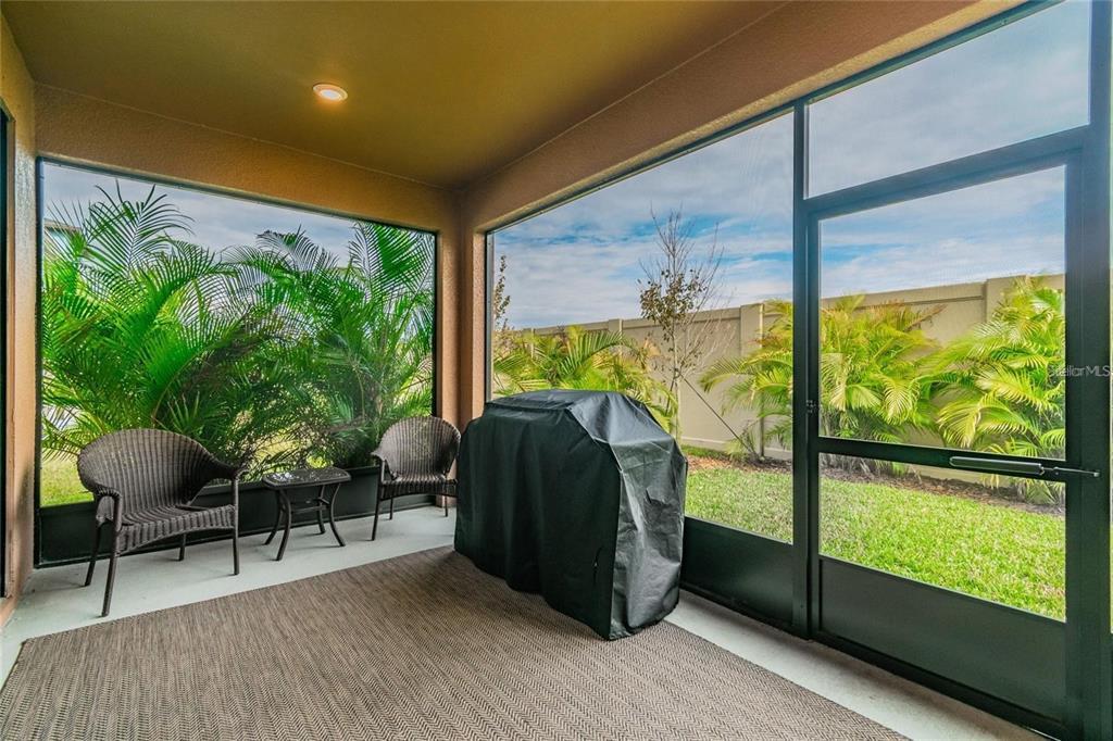 4738 Tramanto Lane Wesley Chapel, FL 33543 - Photo 40 of 45 a living room with large windows and chairs