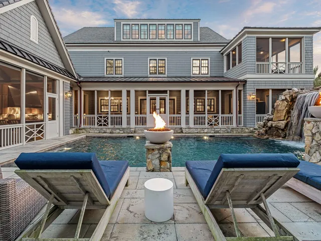 a front view of a house with a yard chairs and table