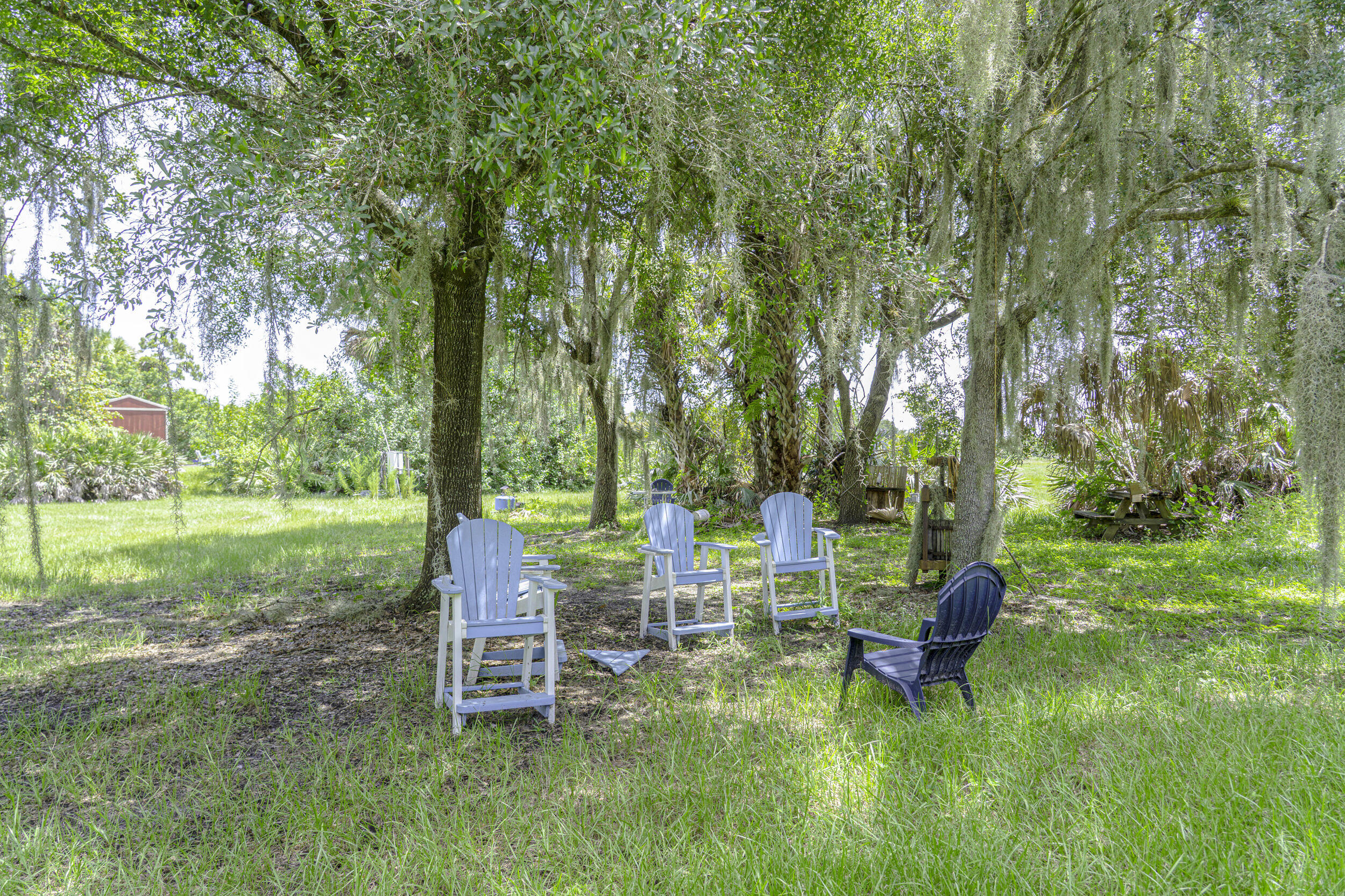 4902 Southwest Wild Turkey Lane Okeechobee, FL 34974 - Photo 13 of 17 a backyard of a house with table and chairs