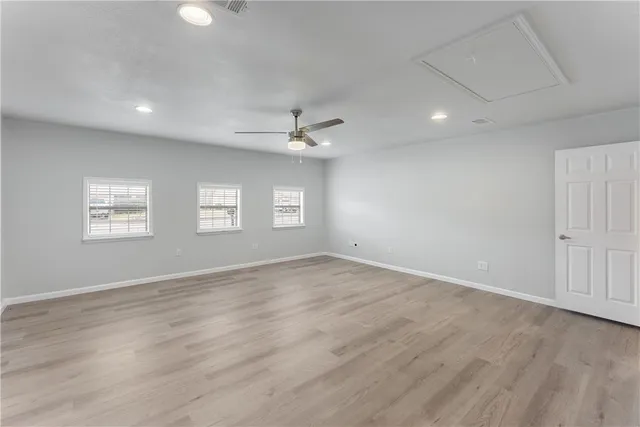 an empty room with windows and fan