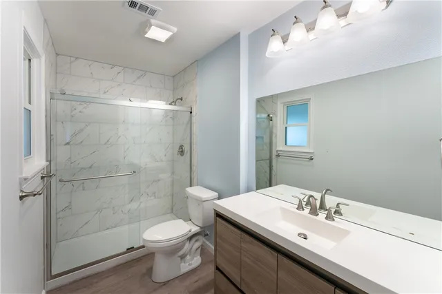 a bathroom with a sink toilet a mirror and shower