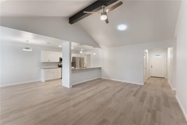a view of empty room with wooden floor and window