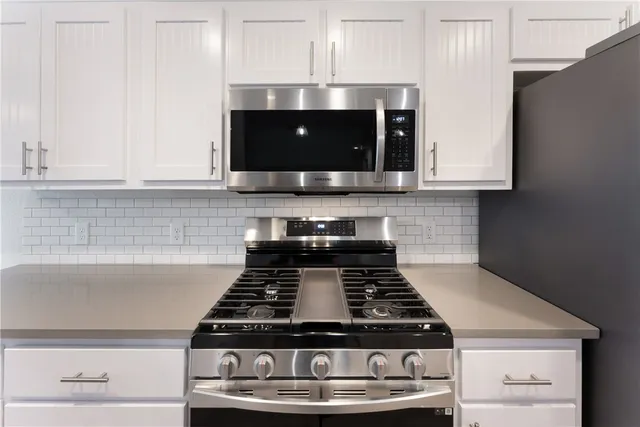 a stove top oven sitting inside of a kitchen