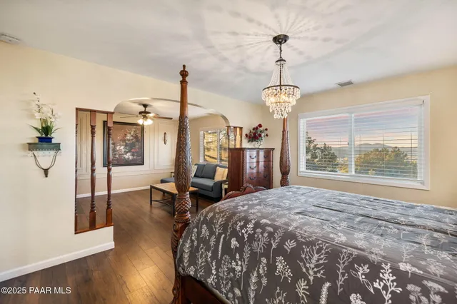 a bedroom with a bed table chair and a window
