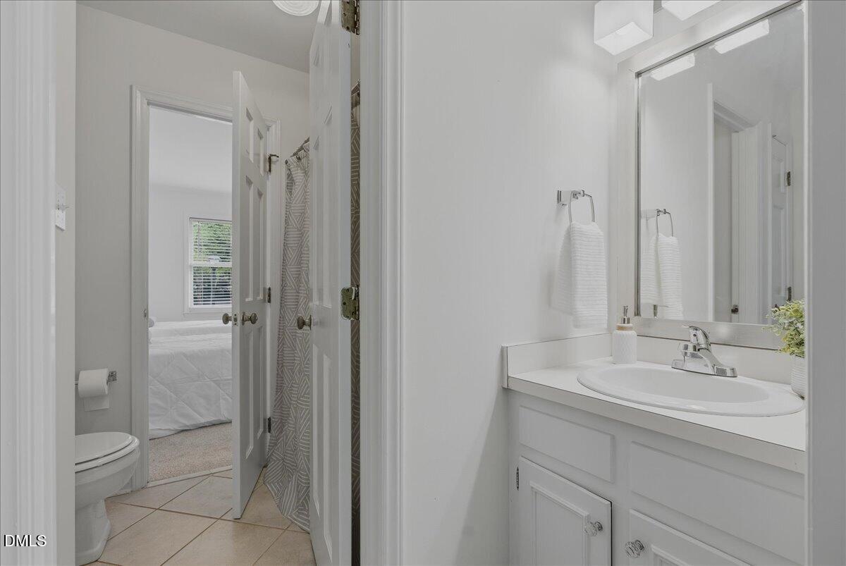2834 Wayland Drive Raleigh, NC 27608 - Photo 16 of 26 a bathroom with a shower sink vanity and mirror