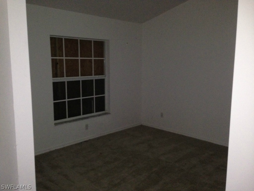 3003 37th Street Southwest Lehigh Acres, FL 33976 - Photo 4 of 13 a view of an empty room with a window