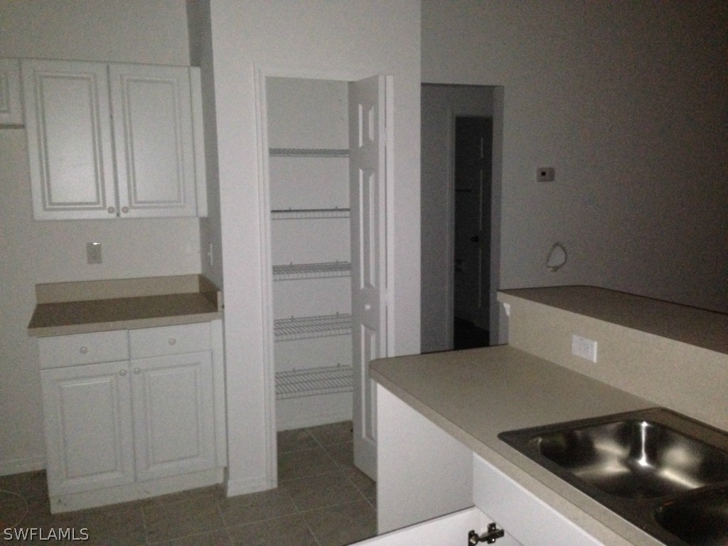 3003 37th Street Southwest Lehigh Acres, FL 33976 - Photo 5 of 13 a kitchen with a sink and a refrigerator