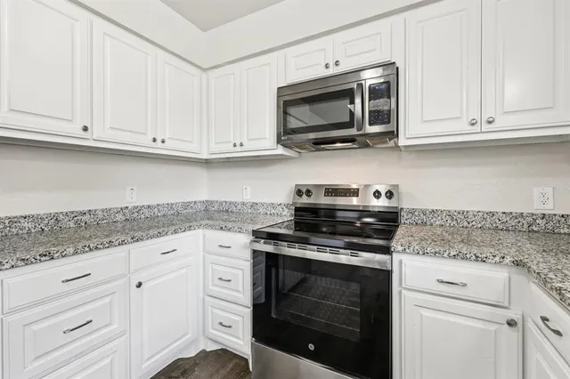 a kitchen with white cabinets and stainless steel appliances