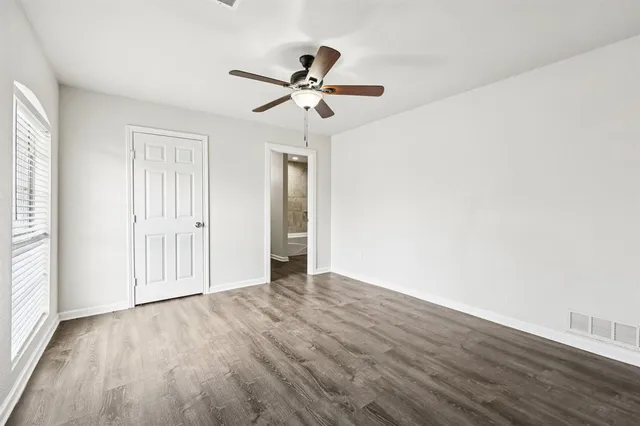 a view of empty room with wooden floor