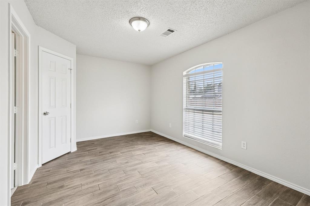 320 Edgewood Street Krum, TX 76249 - Photo 19 of 29 an empty room with wooden floor and windows
