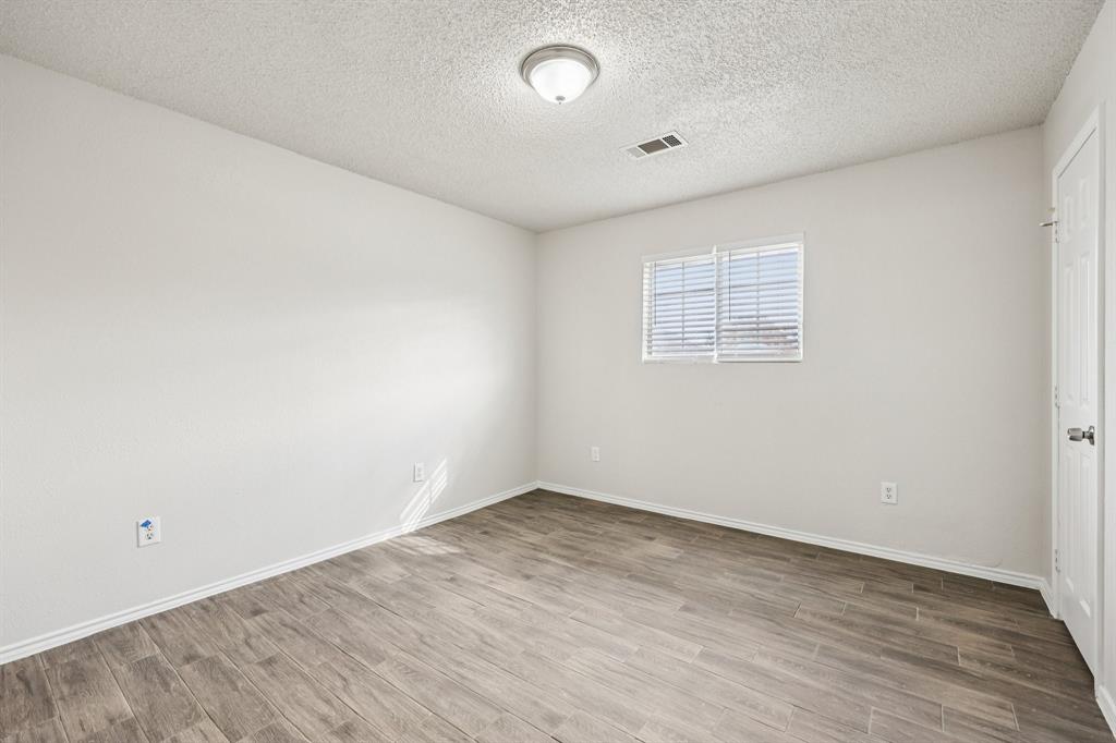 320 Edgewood Street Krum, TX 76249 - Photo 23 of 29 an empty room with wooden floor and windows