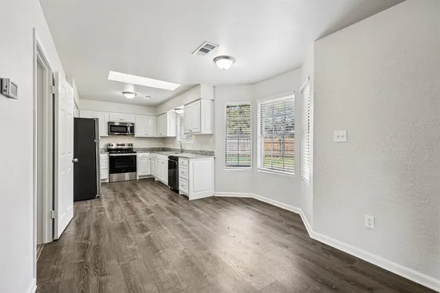 a view of kitchen with wooden floor electronic appliances and window