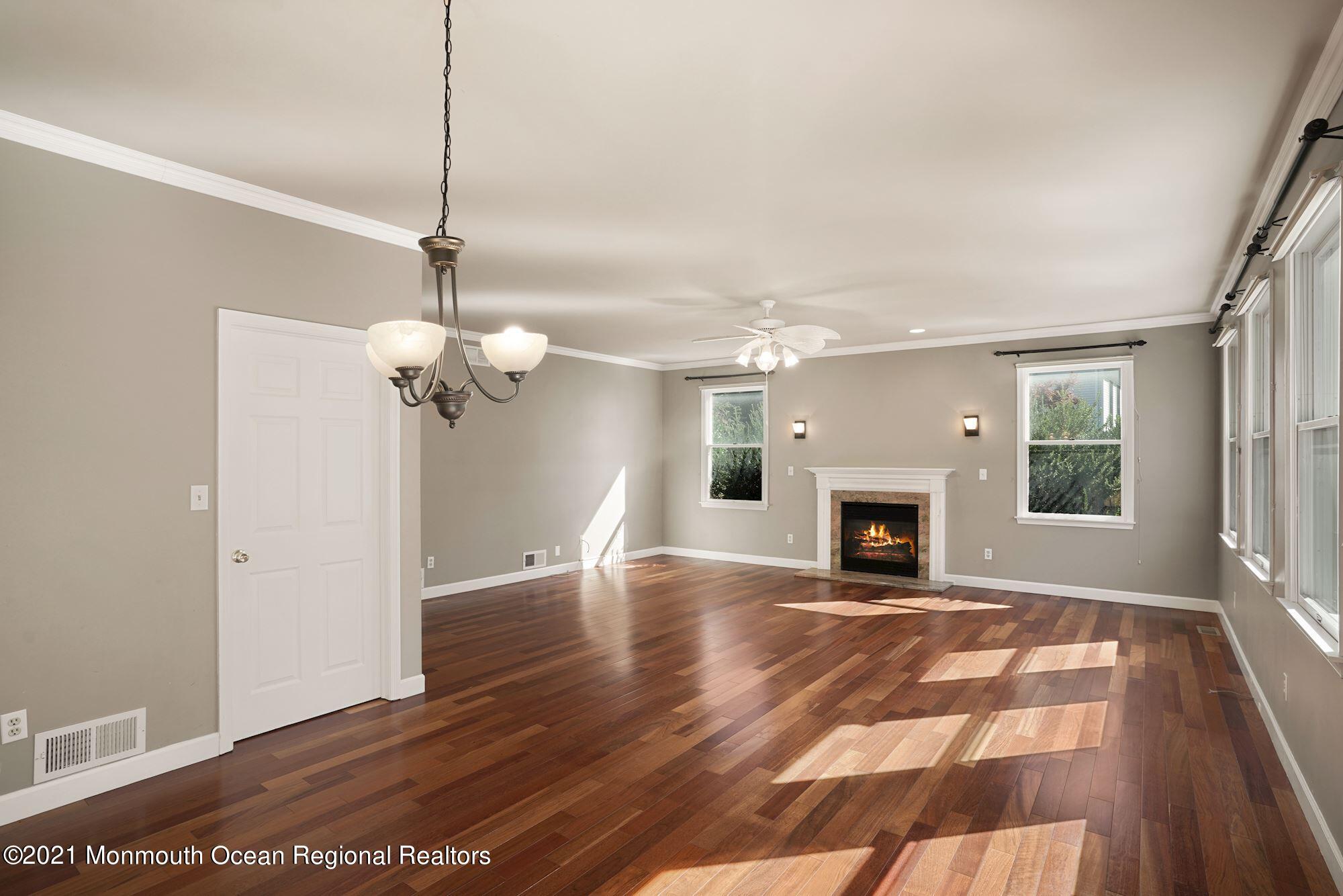 5 Roller Road Asbury Park, NJ 07712 - Photo 24 of 57 a view of a livingroom with wooden floor a fireplace and windows