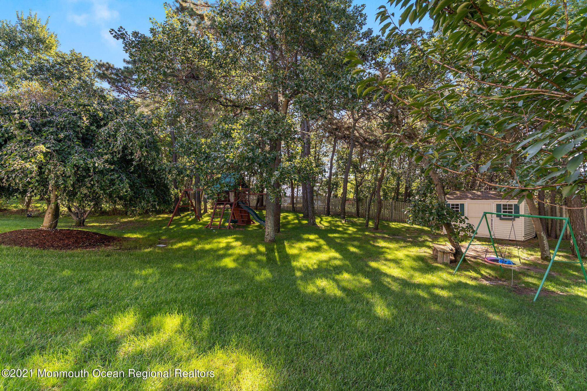 5 Roller Road Asbury Park, NJ 07712 - Photo 55 of 57 a view of a backyard with table and chairs and wooden fence