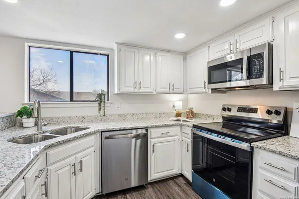 a kitchen with stainless steel appliances granite countertop a sink stove microwave and cabinets