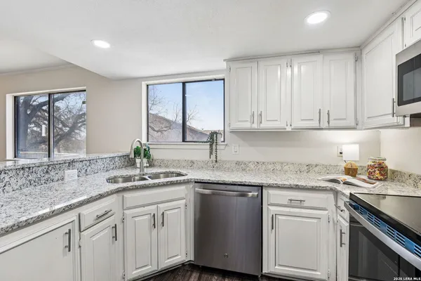 a kitchen with stainless steel appliances granite countertop a sink stove and cabinets
