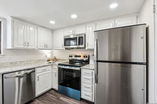 a kitchen with stainless steel appliances a refrigerator stove and microwave