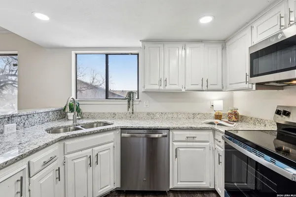 a kitchen with stainless steel appliances granite countertop a sink stove and cabinets