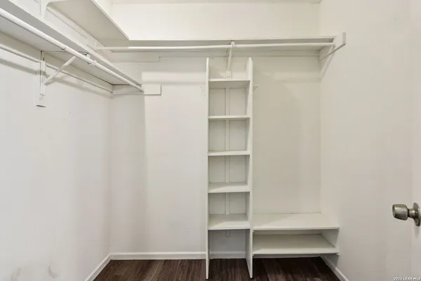 a view of walk in closet with empty racks