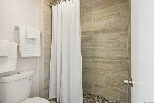 a bathroom with a toilet and a shower