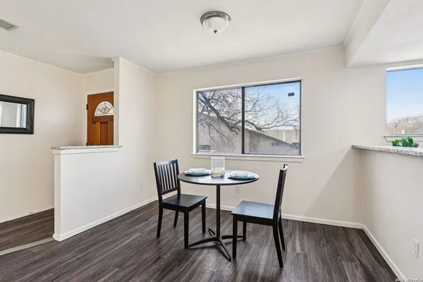 a view of a dining room with furniture wooden floor and painting on the wall