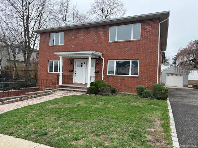5 Linwood Road North, Unit 1 Port Washington, NY 11050 - Photo 1 of 12 Traditional-style house featuring an outbuilding, brick siding, and a detached garage