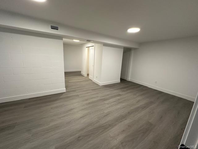 5 Linwood Road North, Unit 1 Port Washington, NY 11050 - Photo 11 of 12 Finished below grade area featuring concrete block wall, dark wood-style floors, and recessed lighting