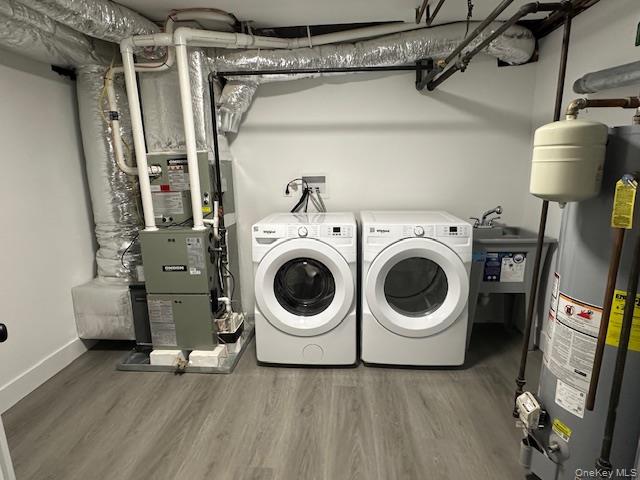 5 Linwood Road North, Unit 1 Port Washington, NY 11050 - Photo 12 of 12 Laundry area with water heater, light wood-style flooring, and separate washer and dryer