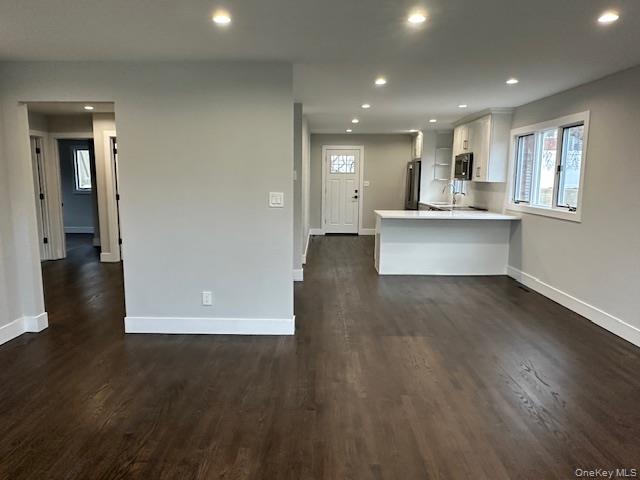 5 Linwood Road North, Unit 1 Port Washington, NY 11050 - Photo 2 of 12 Kitchen with white cabinetry, a peninsula, recessed lighting, dark wood-style floors, and light stone counters
