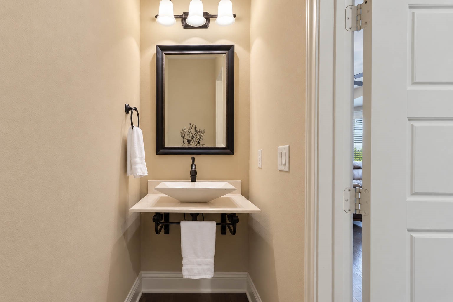 91 Lake View Loop Fulshear, TX 77441 - Photo 22 of 42 This stylish powder bathroom features a floating vessel sink, a framed mirror, an updated lighting fixture, and elegant dark hardware throughout.